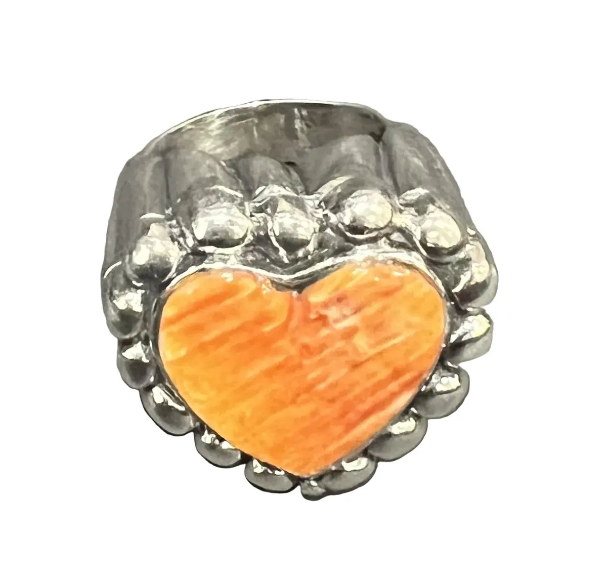 A silver-toned ring featuring a large, polished orange heart-shaped stone in the center.