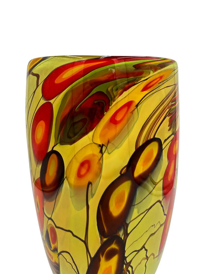A handblown glass vase titled 'Solar Boom' featuring bold, abstract splashes of red, orange, yellow, and black with flowing organic patterns. Dimensions are approximately 7 inches wide, 12 inches deep, and 13 inches high, weighing 6.35 pounds. Perfect as a statement piece or for avant-garde floral displays in contemporary spaces.