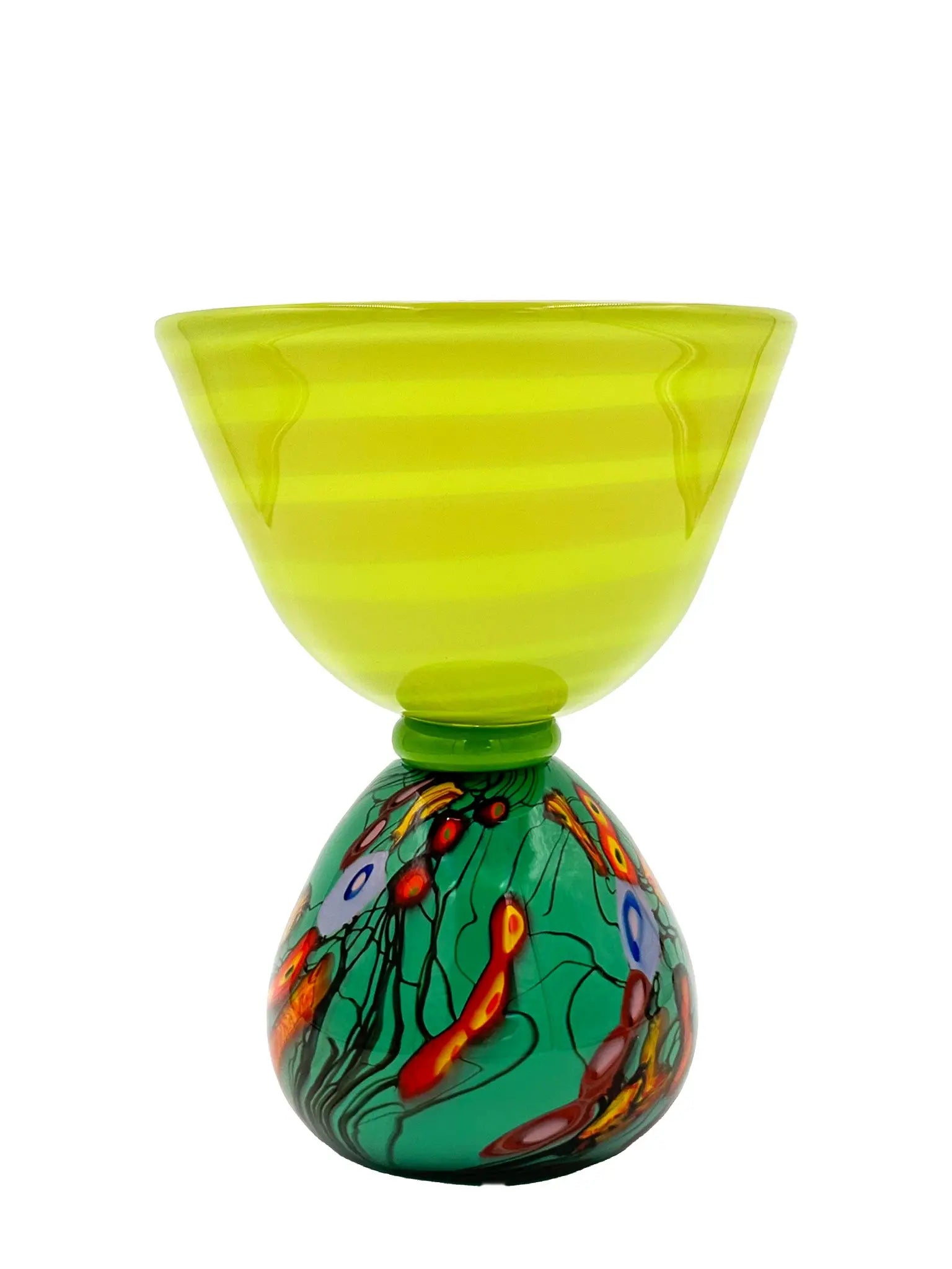 This vibrant glass sculpture, 'Mini Me' by Steve Palmer, showcases a bold abstract design with colorful swirls and organic patterns on a rounded base, contrasted by a translucent lime green top with subtle horizontal stripes. Its playful colors and shapes make it a striking statement piece suitable for contemporary and artistic settings. Dimensions are approximately 7 inches wide, 9 inches high, and 4.5 inches deep, weighing 4.4 pounds, and it is crafted from handblown glass.