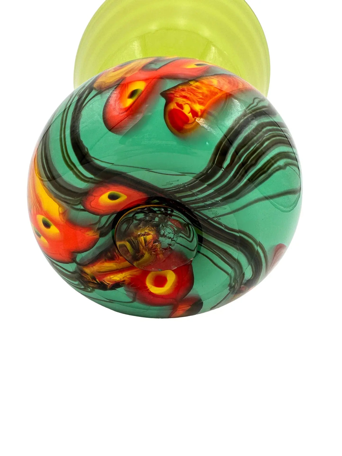 This vibrant glass sculpture, 'Mini Me' by Steve Palmer, showcases a bold abstract design with colorful swirls and organic patterns on a rounded base, contrasted by a translucent lime green top with subtle horizontal stripes. Its playful colors and shapes make it a striking statement piece suitable for contemporary and artistic settings. Dimensions are approximately 7 inches wide, 9 inches high, and 4.5 inches deep, weighing 4.4 pounds, and it is crafted from handblown glass.
