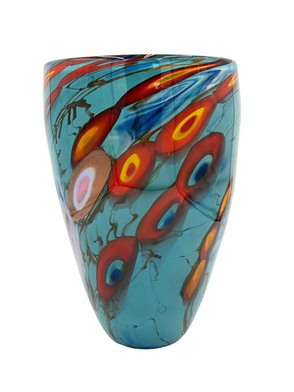 A vibrant glass vessel named Oceanic by Steve Palmer, featuring a turquoise base with abstract swirling patterns in red, orange, and yellow, inspired by flowing tides and coral reefs. The vessel measures approximately 7.75 inches wide, 12 inches tall, and 7.75 inches deep, weighing 5.95 pounds. Suitable as a sculpture or floral display.
