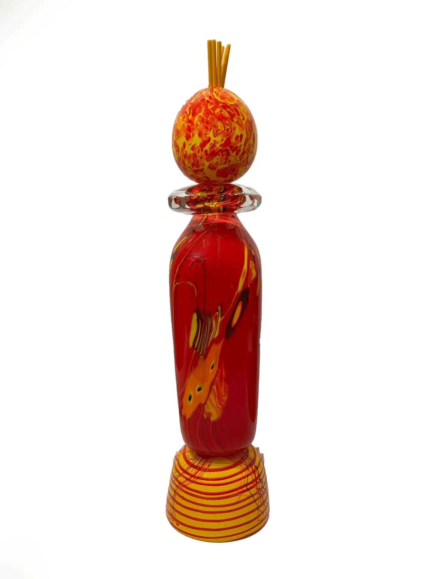 A vivid red glass sculpture titled "Red Inferno" by renowned American artist Steve Palmer features swirling yellow and orange accents, a decorative orb, and flame-colored spikes. Handblown with rich warm hues, it's a striking collector’s piece measuring 30 inches tall and weighing 20.7 lbs.