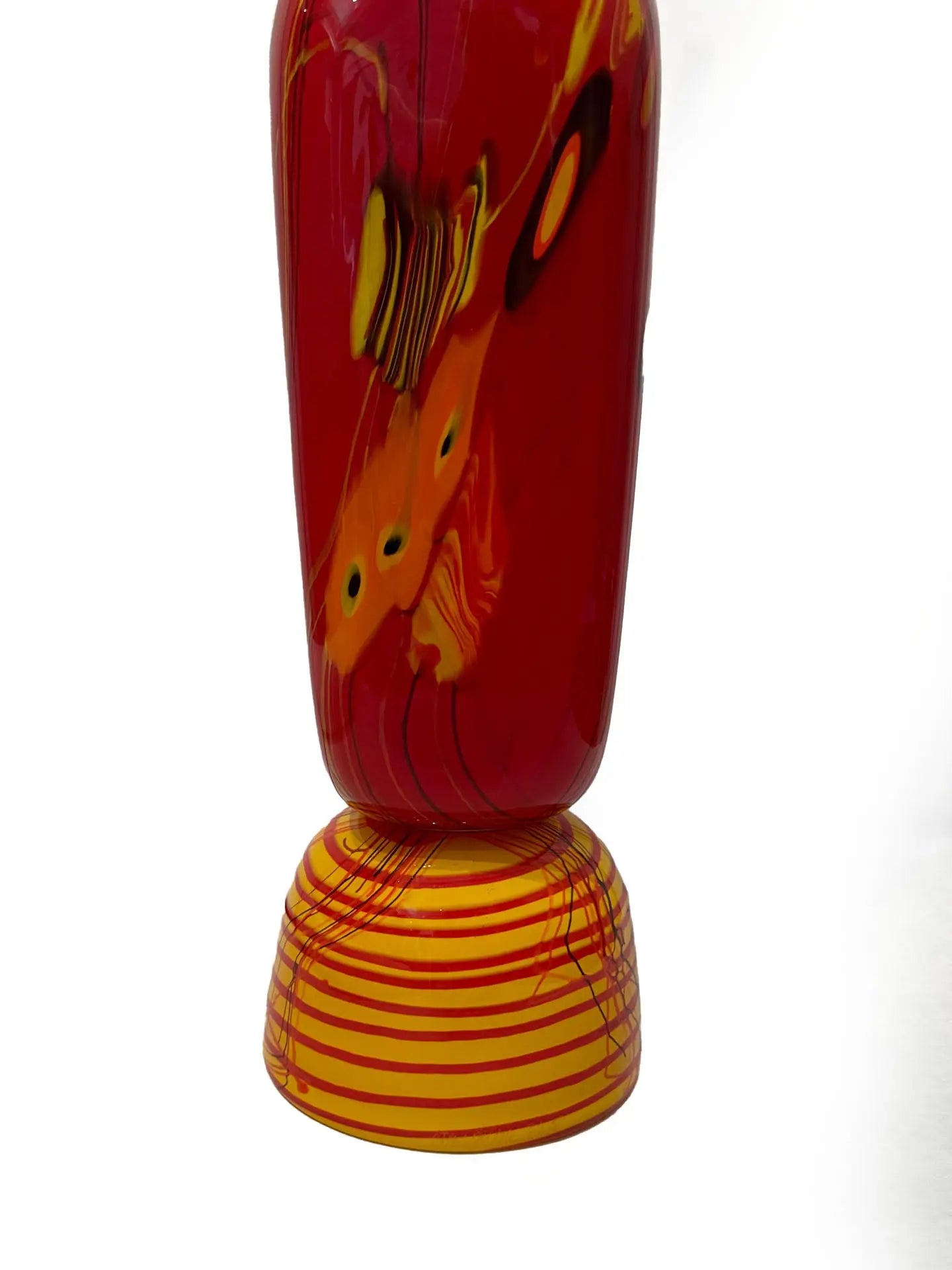 A vivid red glass sculpture titled "Red Inferno" by renowned American artist Steve Palmer features swirling yellow and orange accents, a decorative orb, and flame-colored spikes. Handblown with rich warm hues, it's a striking collector’s piece measuring 30 inches tall and weighing 20.7 lbs.