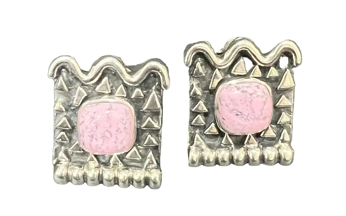 A pair of silver-toned square earrings with a central pink cabochon stone and textured geometric borders.