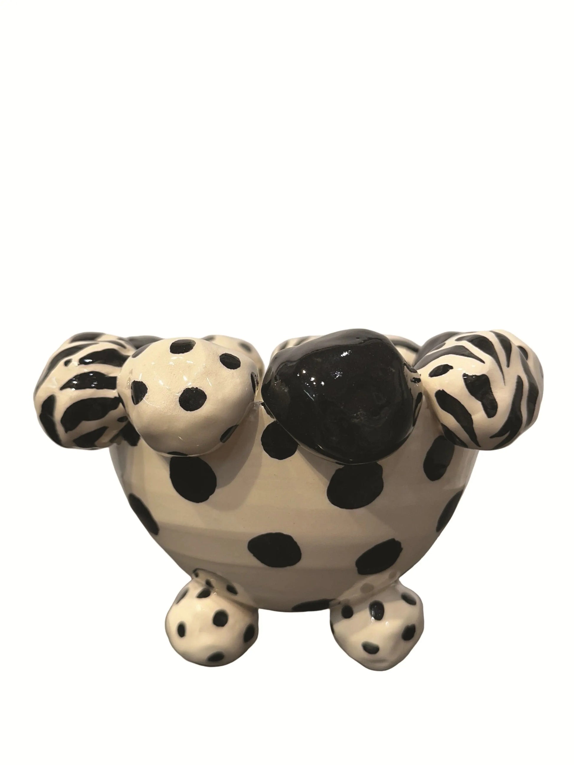 This handmade ceramic footed bowl, designed by Mary Rose Young, features a bold black and cream pattern with hand-painted dots, zebra stripes, and solid black accents. The sculpted dotted feet complement the playful rim, adding charm and balance. Measuring approximately 8 inches wide, 8 inches deep, and 5 inches high, this striking piece serves as both a functional bowl and a decorative statement, perfect for enhancing any table, shelf, or display with artistic flair.