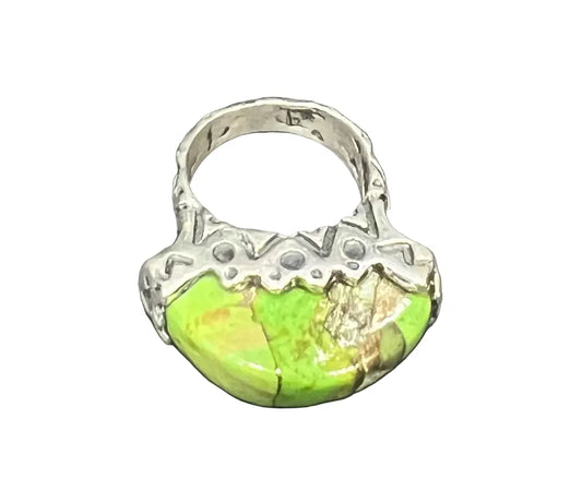A silver ring featuring a large, organic-shaped green stone with natural matrix cracks. worn on its own, it can also be stacked with other rings for a layered, collected look.